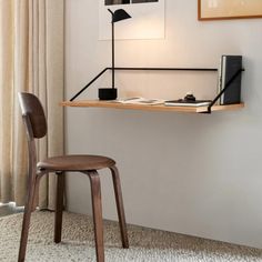 a wooden chair sitting in front of a desk with a lamp on top of it