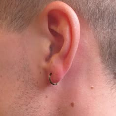 a close up of a man's ear with a nose ring