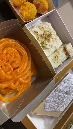 two boxes filled with different types of food on top of a table next to each other