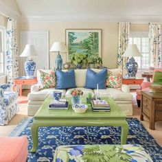 a living room filled with lots of furniture and colorful pillows on top of it's couches