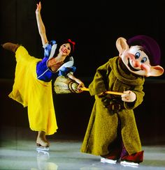 two people dressed in costumes performing on stage