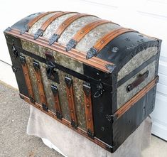 an old trunk sitting on top of a white towel next to a garage door,