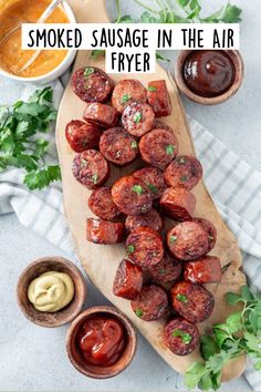 smoked sausages in the air fryer on a wooden cutting board with dipping sauce