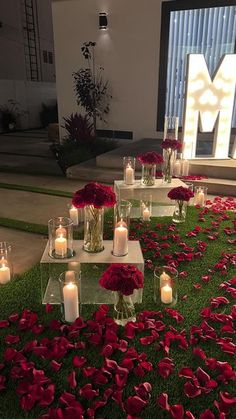 candles and flowers on the ground in front of a large m sign that reads mm