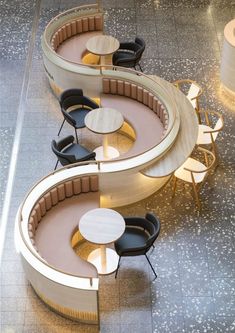 an overhead view of two circular tables and chairs in a room with concrete flooring