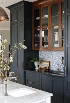 a kitchen with black cabinets and white counter tops