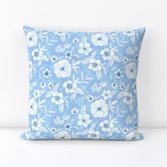 a blue pillow with white flowers on it