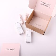 an open box with some skin care products in it on a white surface next to other items