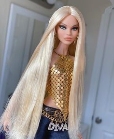 a barbie doll with blonde hair and blue eyes wearing gold sequins on it's chest