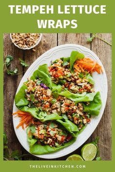 lettuce wraps with carrots and other vegetables on a white plate next to lime slices