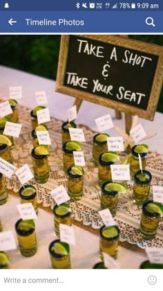 there are many shot glasses with limes in them sitting on the table next to each other