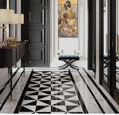 a hallway with black and white marble flooring, an art work on the wall