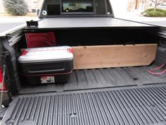 the back end of a pickup truck with its bed up and two coolers in it