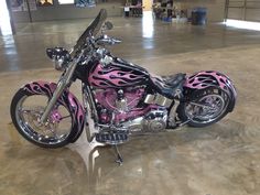 a pink and black motorcycle with flames painted on it