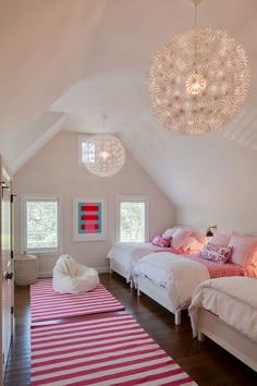 two beds in a room with pink and white decor on the walls, along with a rug