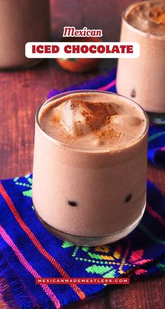 two glasses filled with iced chocolate drink on top of a blue and red table cloth