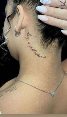 a woman with tattoos on her neck and behind her ear