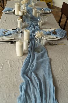 the table is set with candles, plates and napkins