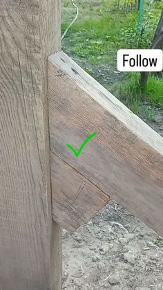 a close up of a wooden fence with a green arrow pointing to the left side