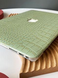 a green macbook air case sitting on top of a white table with red circles around it