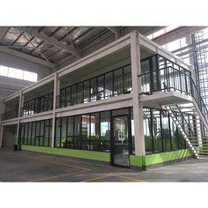 an empty building with stairs leading up to the second floor and windows on each side