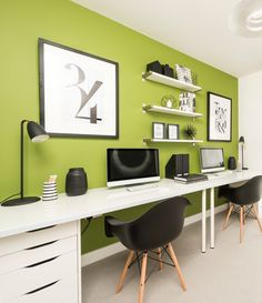 an office with green walls and white desks, black chairs, and pictures on the wall