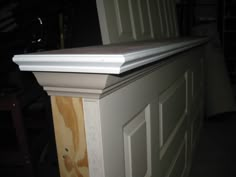 the top of a white cabinet with wood paneling on it's sides and bottom