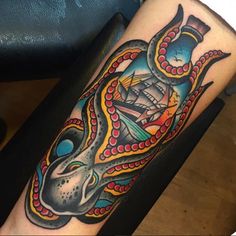 an octopus with a ship in the background tattoo design on arm and leg, done by person