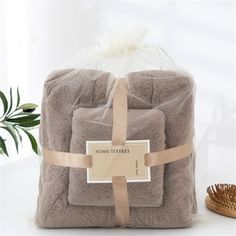 a stack of towels wrapped in brown and white with a bamboo brush next to it