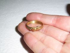 a person holding a gold ring in their hand