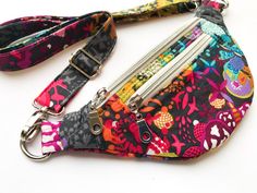 a multicolored purse with zippers on the bottom and an id holder attached to it