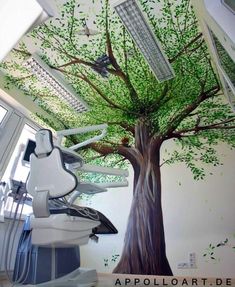 a tree painted on the side of a wall next to a dentist's chair