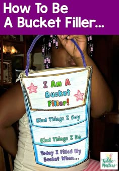 a woman holding up a bucket filled with words on the front and back of it