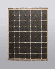 a black and white rug with squares on it, in the middle of a gray background