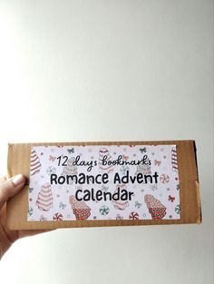 someone is holding up a calendar that says, 12 days bookmarks romance adventure calendar