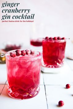 two glasses filled with cranberry gin cocktail on a white tiled surface and the text ginger cranberry gin cocktail