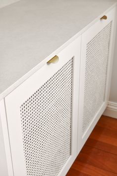 a white cabinet sitting on top of a hard wood floor