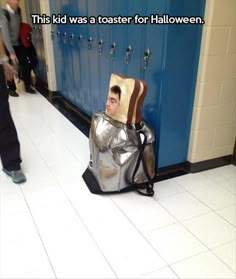 a man sitting on the floor in a suit of armor next to lockers with doors