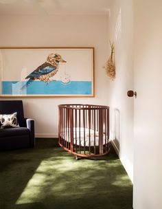 a baby crib in the corner of a room with a painting on the wall