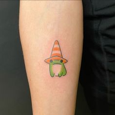 a person with a tattoo on their arm wearing a hat and holding a green apple