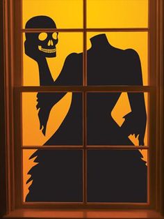 a window with a silhouette of a skeleton holding a human head in front of it