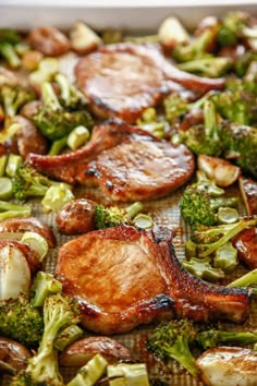 broccoli and other vegetables are being cooked in a baking pan on the table