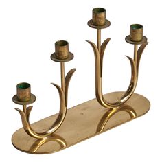 a brass candle holder with three candles on it's sides and two smaller ones in the middle