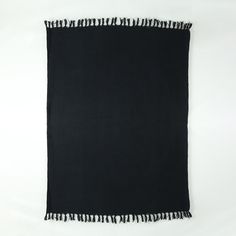 a black scarf with tassels hanging from it's sides on a white background