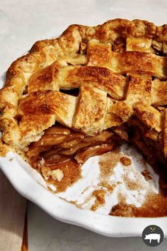 an apple pie is cut in half on a white plate with some powdered sugar