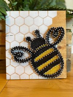 a beaded bee on a wooden block