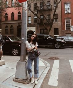 a woman leaning on a stop sign at an intersection