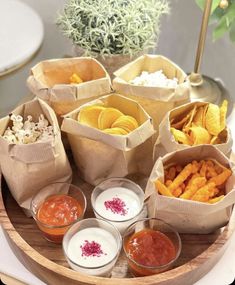 a wooden tray topped with different types of food next to sauces and condiments