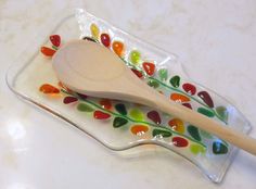 a wooden spoon sitting on top of a glass plate filled with gummy candies