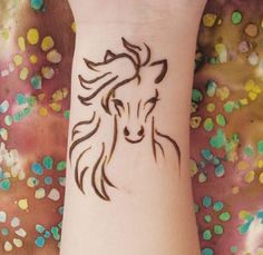 a woman's wrist with a horse tattoo on it